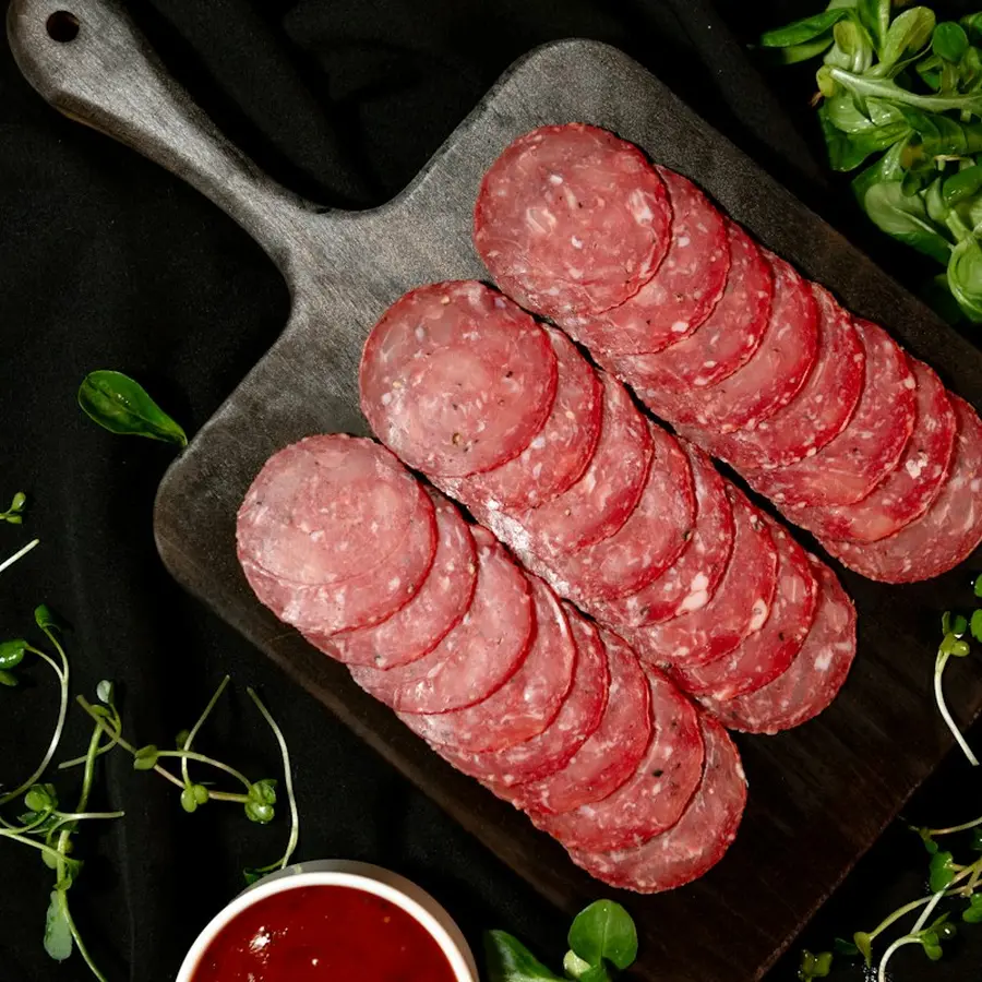 Slices of salchichón on a dark wooden board